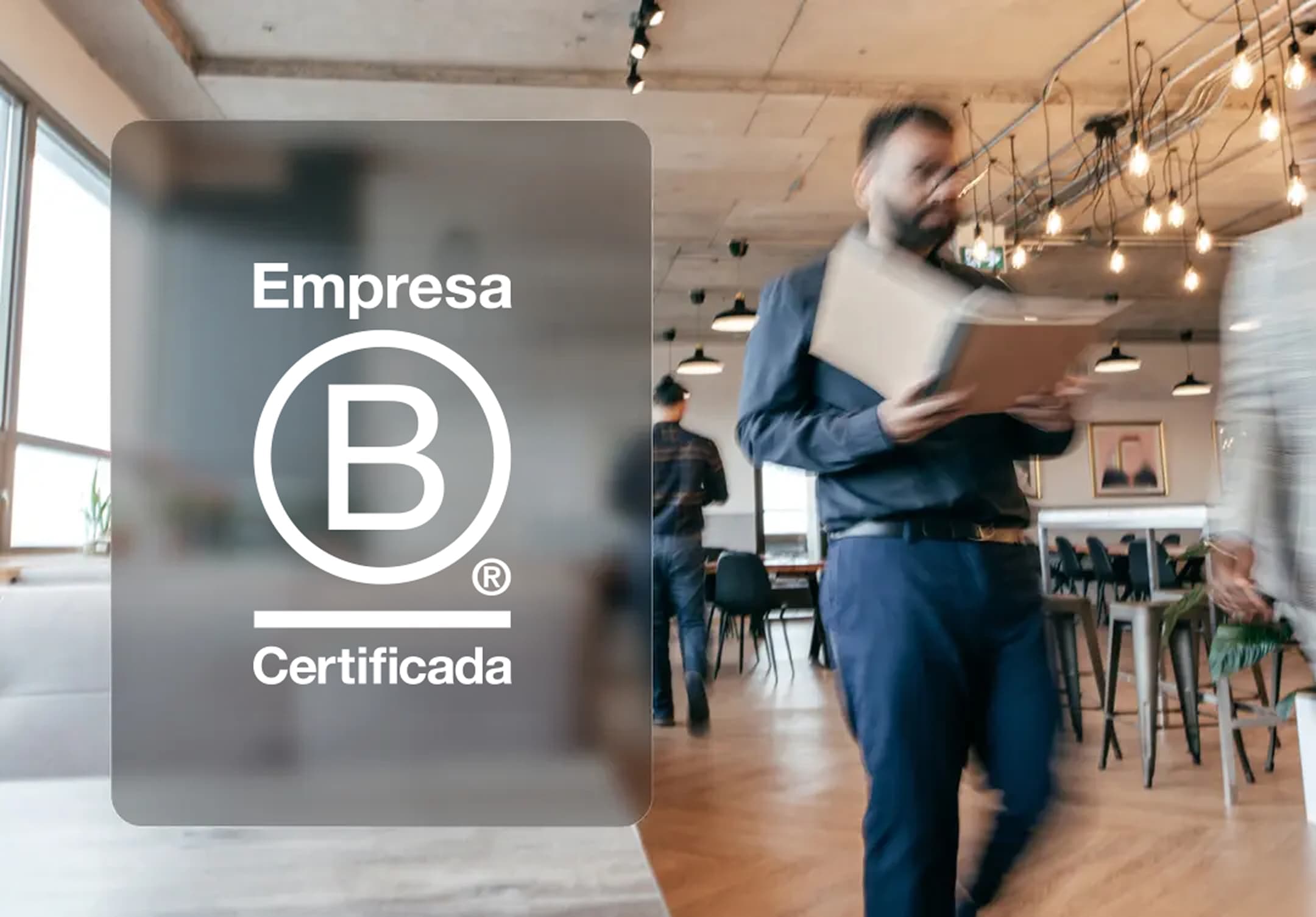 Um homem se movimenta em um escritório e ao seu lado existe uma montagem com o logotipo de empresa B certificada